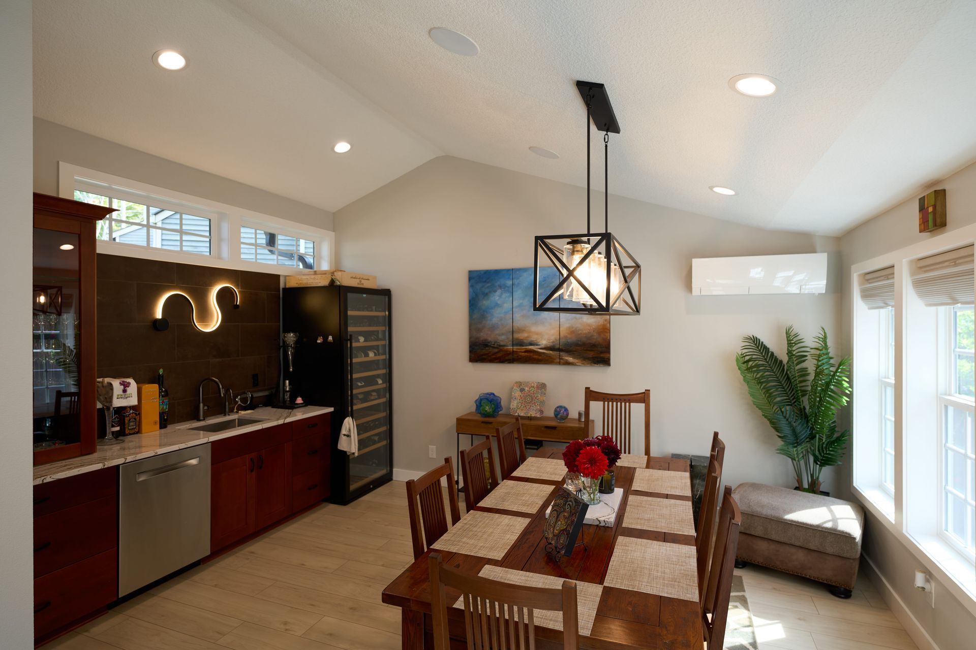 A dining room with a table and chairs and a wine cooler.