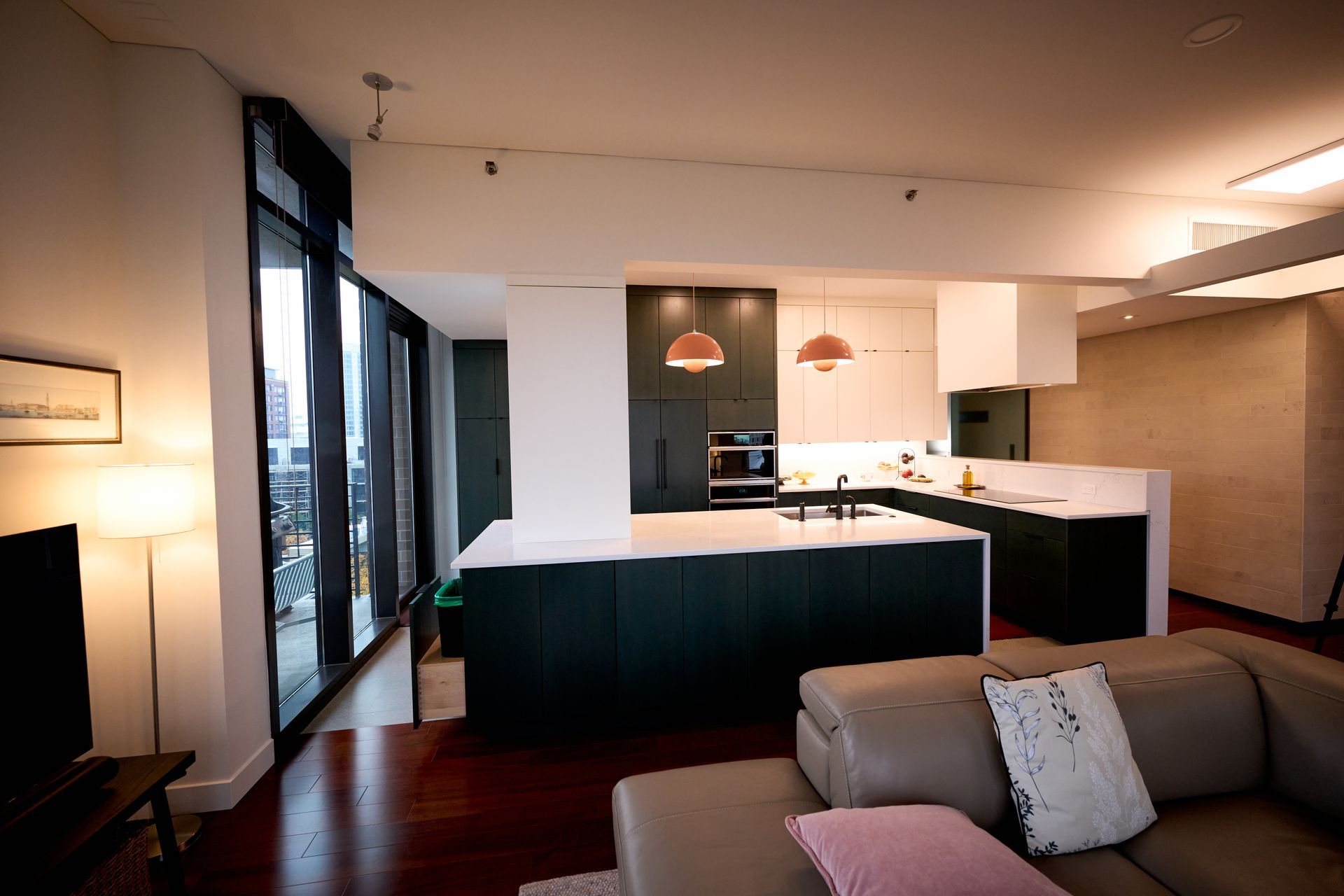 A living room with a couch and a kitchen in the background.