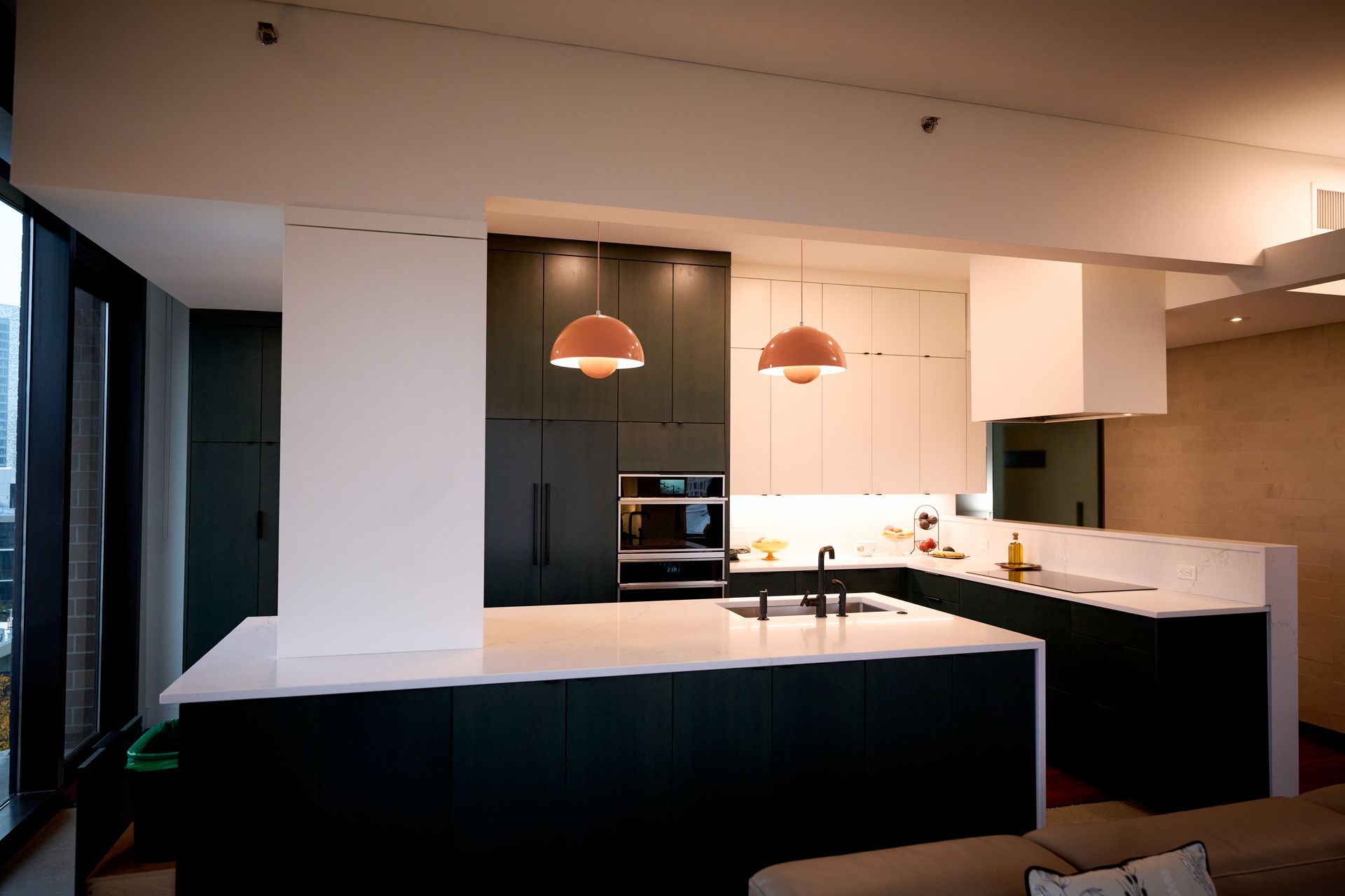 A kitchen with black cabinets and white counter tops.
