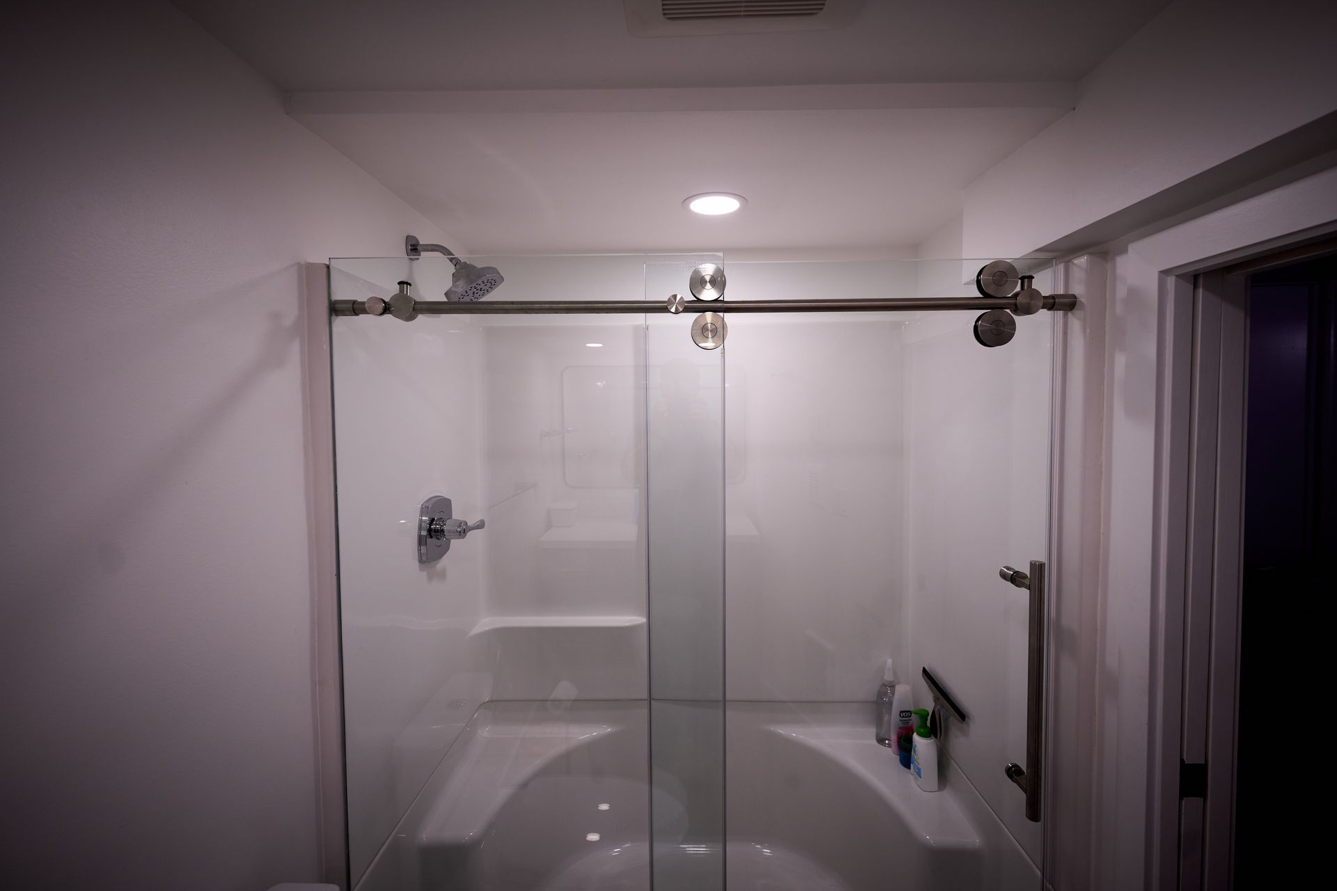 A bathroom with a sliding glass shower door and a bathtub.