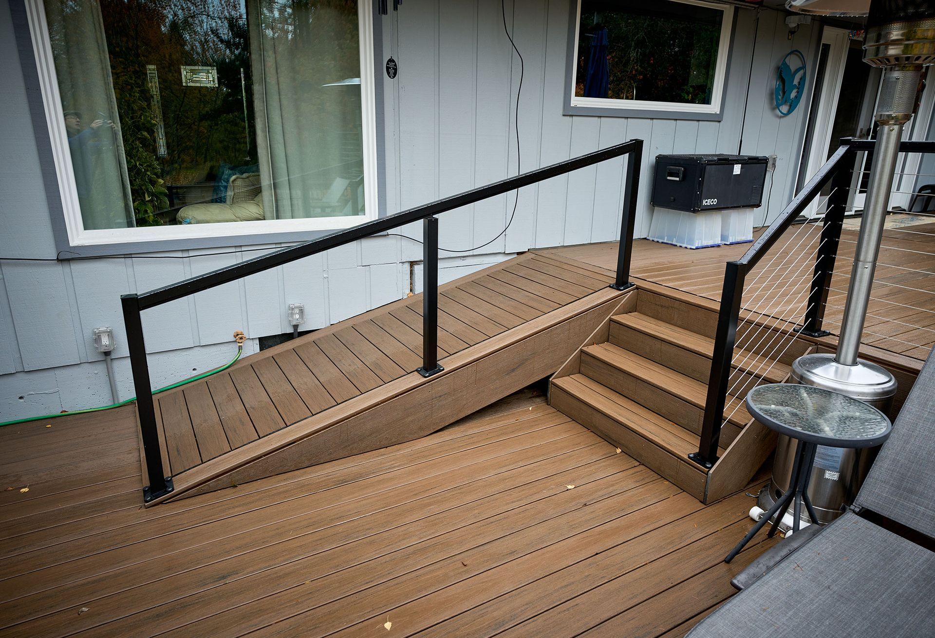 A wooden deck with stairs and a ramp leading to it