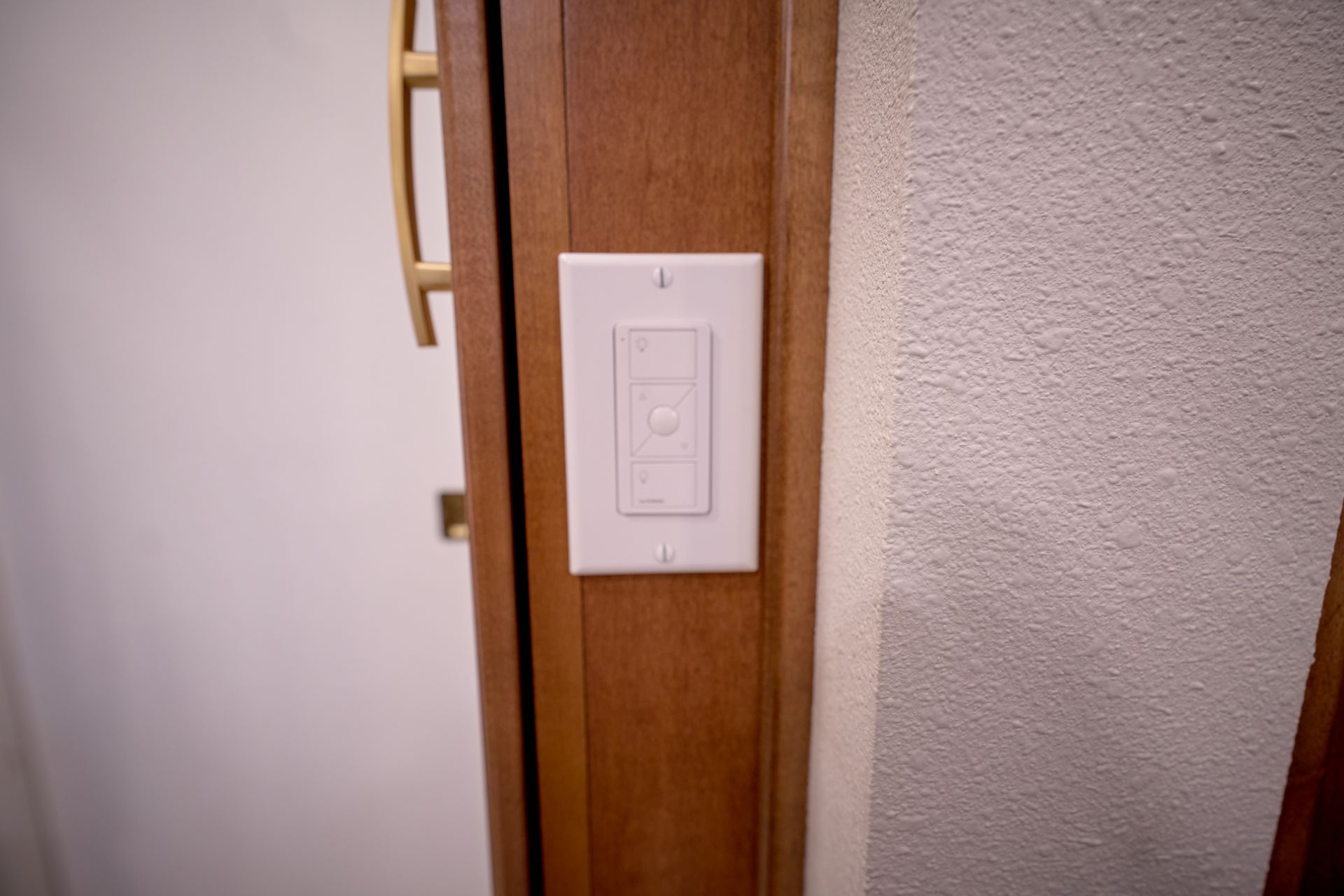 A white light switch is mounted on the side of a door.