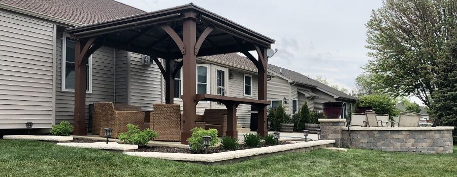 there is a wooden gazebo in the backyard of a house