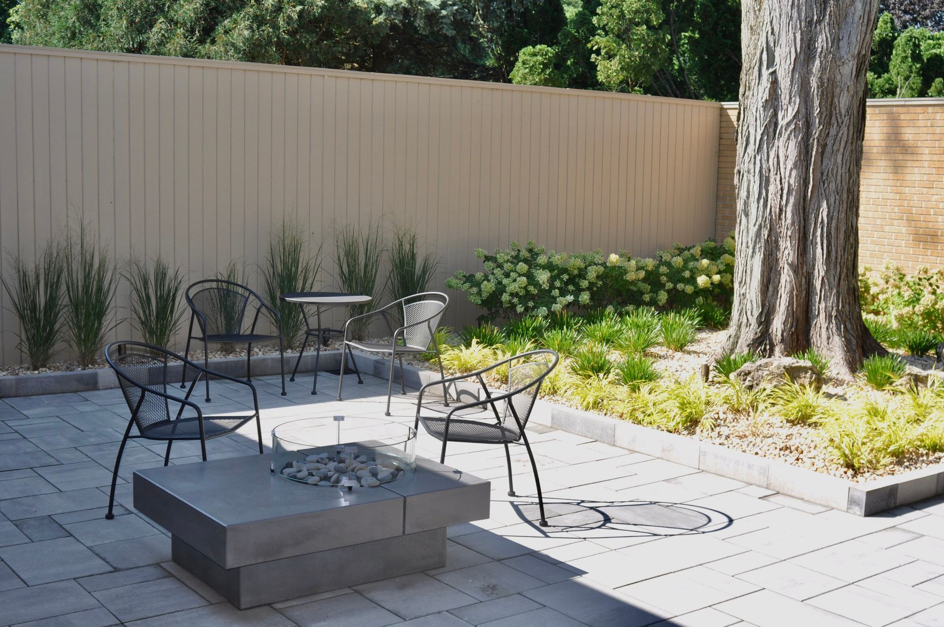 a patio with a table and chairs and a fire pit