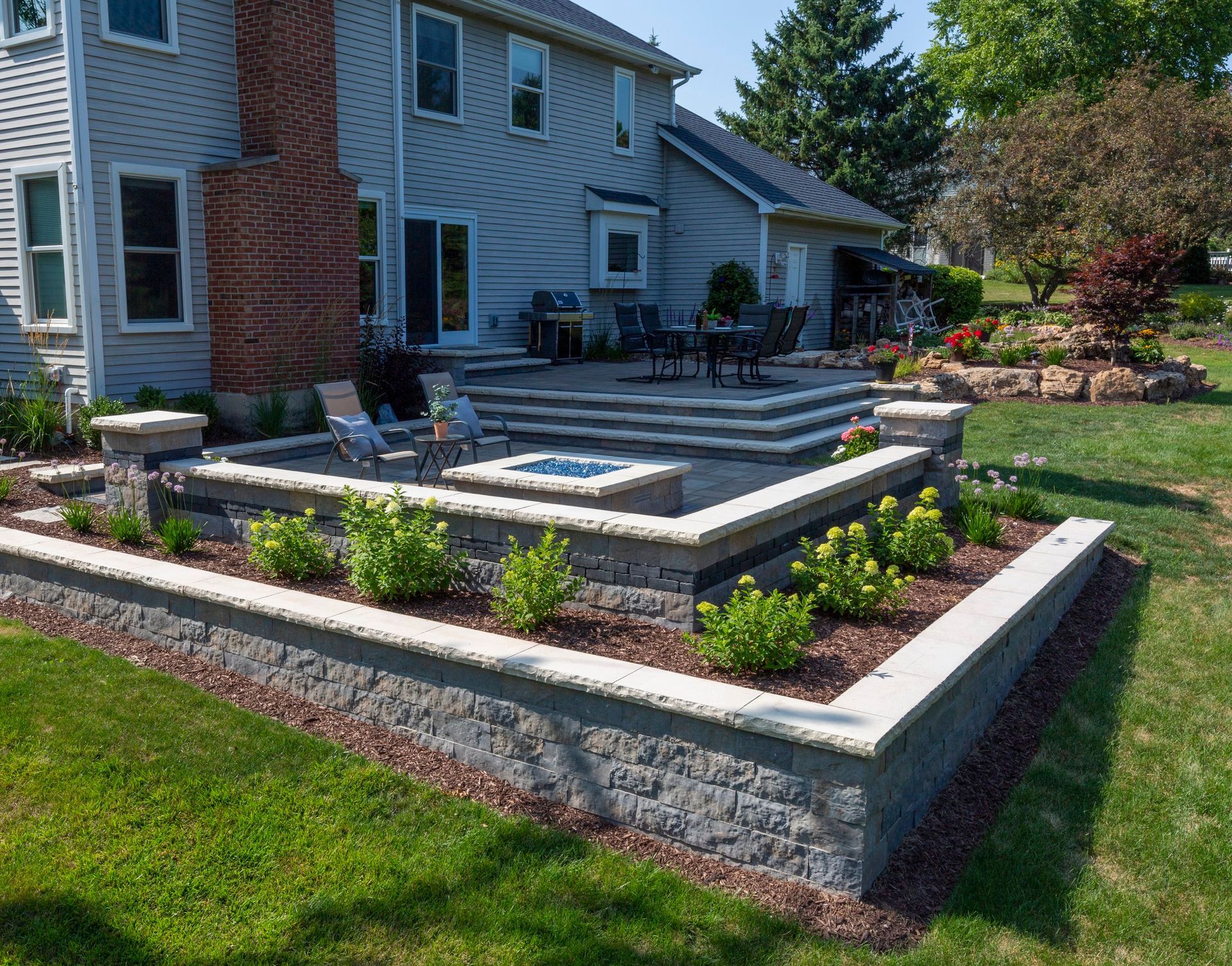 a house with a patio and a brick wall in front of it