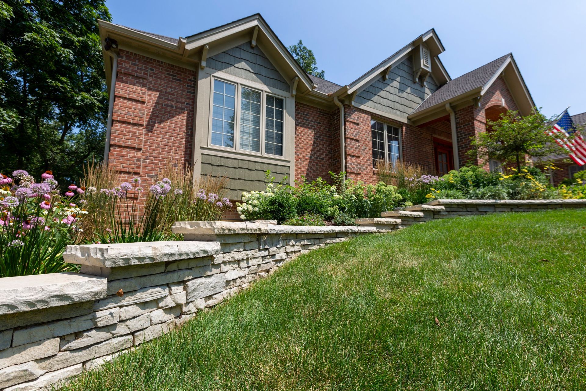 a large brick house with a stone wall in front of it