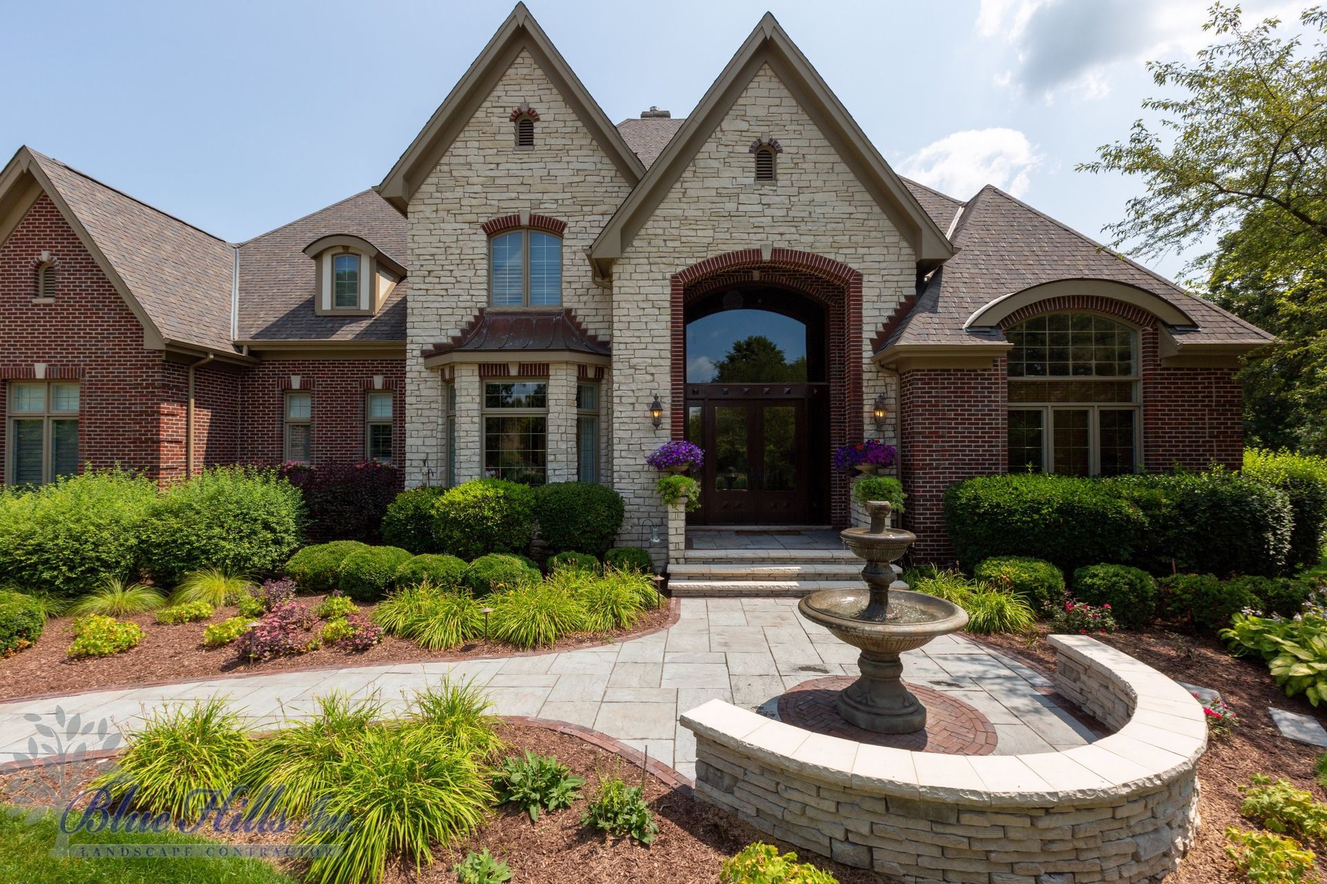 a large brick house with a fountain in front of it