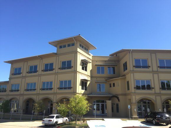 A large building with a lot of windows and cars parked in front of it