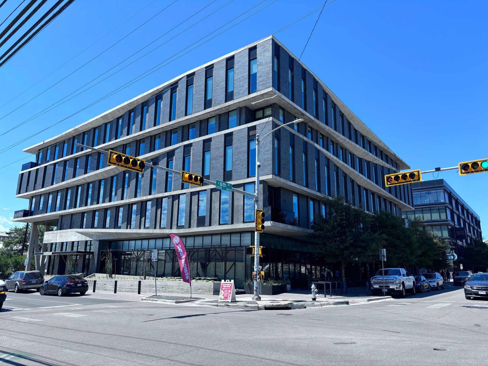 A large building with a lot of windows and a traffic light in front of it