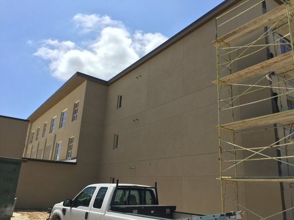 A white truck is parked in front of a building under construction