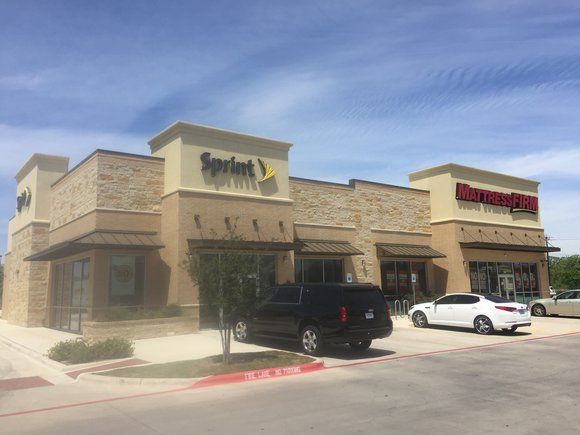A sprint store with cars parked in front of it
