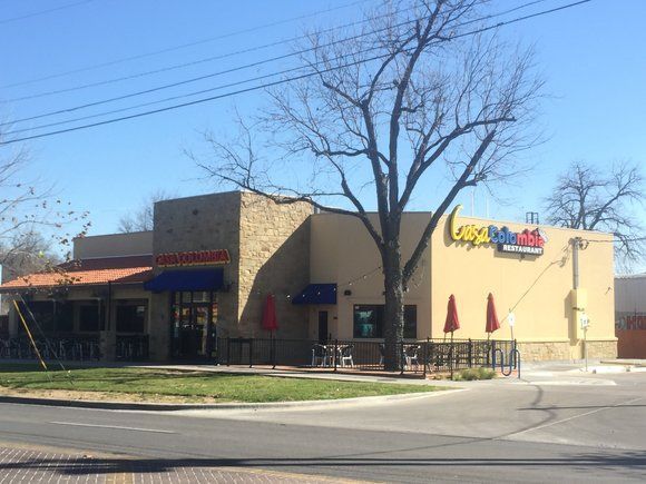 A fast food restaurant with a tree in front of it