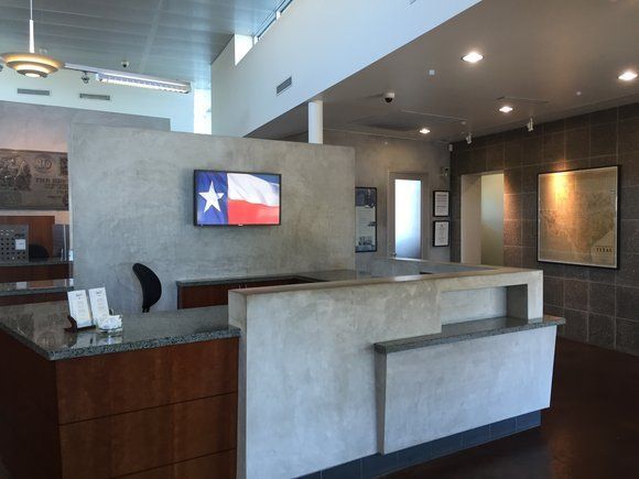 A texas flag is hanging on a wall above a reception desk