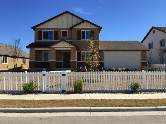 A house with a white picket fence in front of it