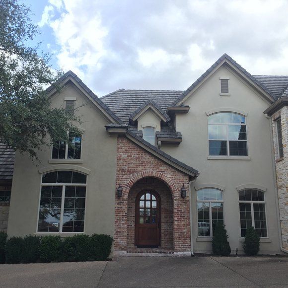 A large house with a lot of windows and a brick archway