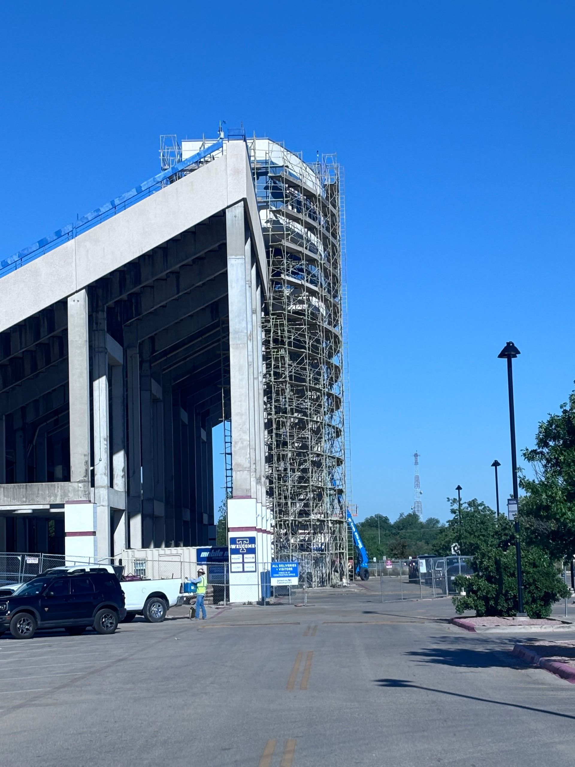 A large building under construction with a tanker truck parked in front of it.
