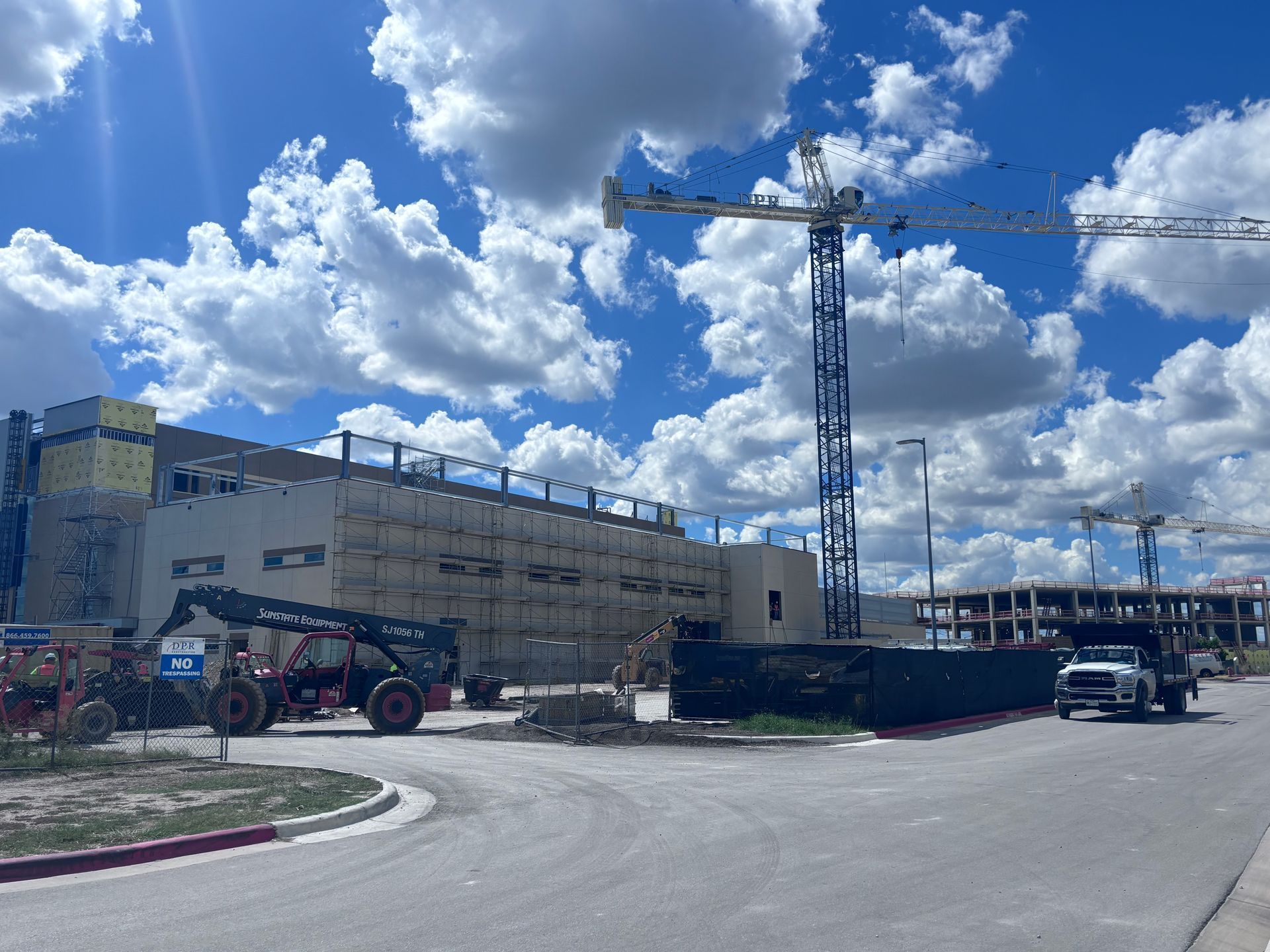 A construction site with a lot of trucks and cranes