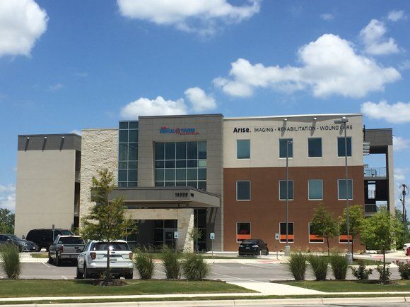 A large building with a lot of windows and a sign that says ' dental ' on it