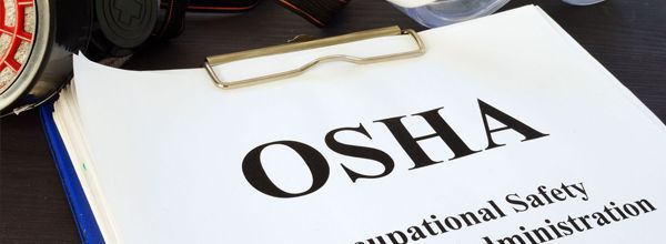 OSHA document on a clipboard with a partial view of safety equipment.