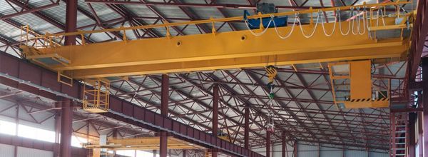 Yellow overhead crane inside a warehouse.