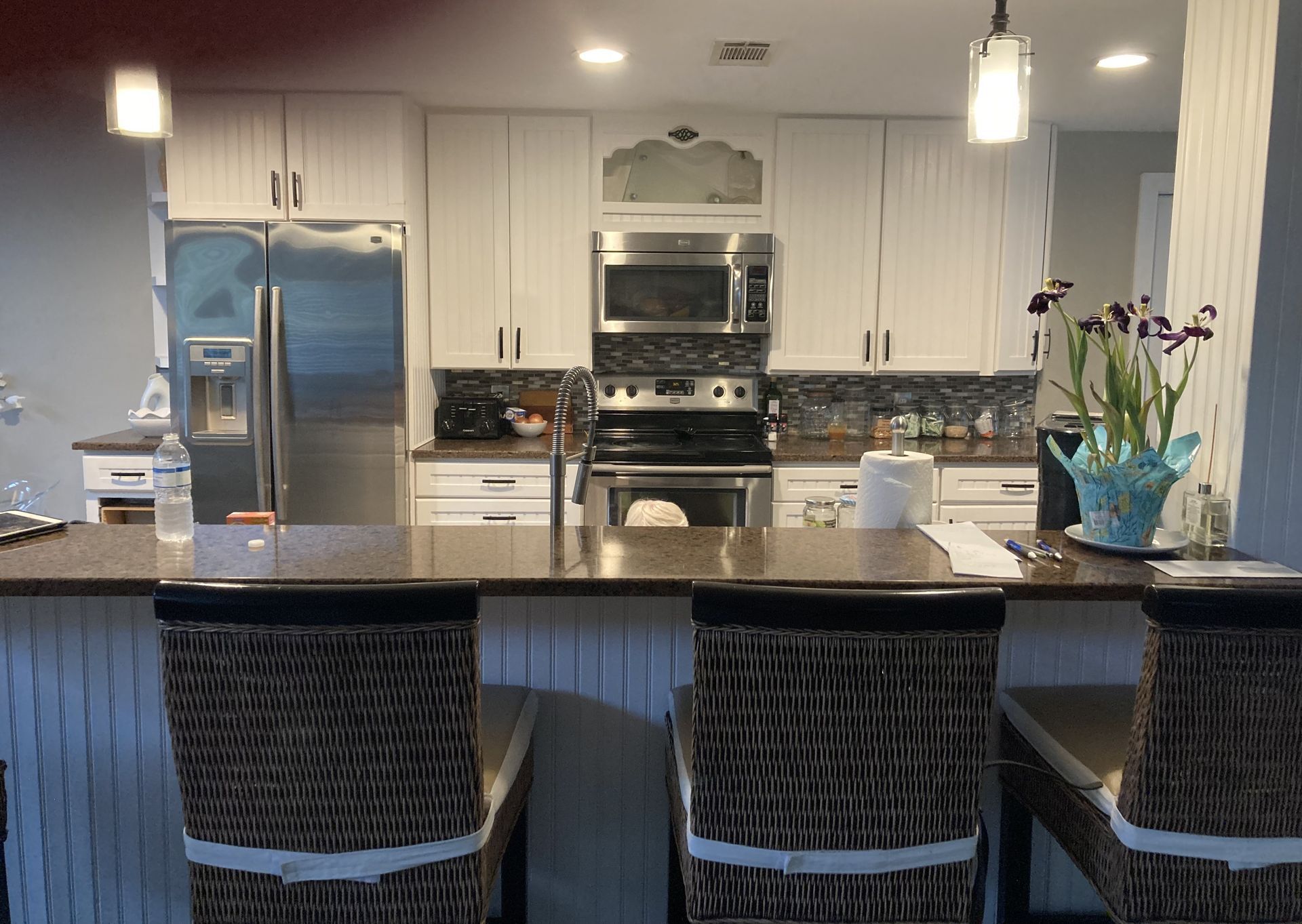 A kitchen with white cabinets and stainless steel appliances