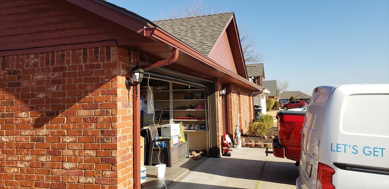 Brick garage with open door, silver van and red truck parked in the driveway.