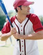 A man in a red hat is holding a baseball bat.