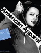 A woman is wearing a hoodie and holding a sign that says