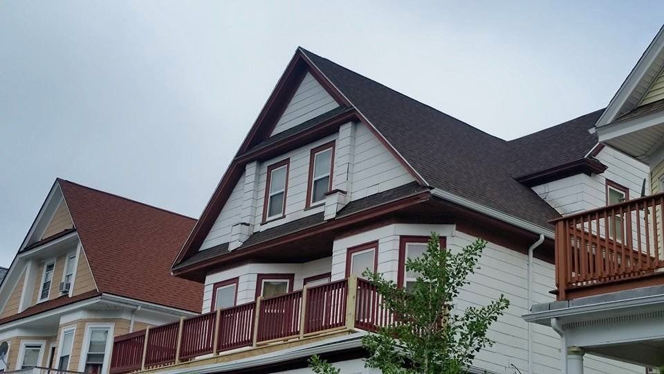 A white house with a red roof and a balcony