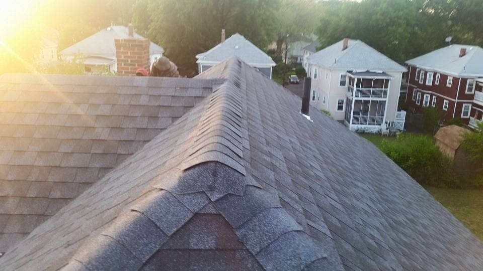 The sun is shining on the roof of a house.