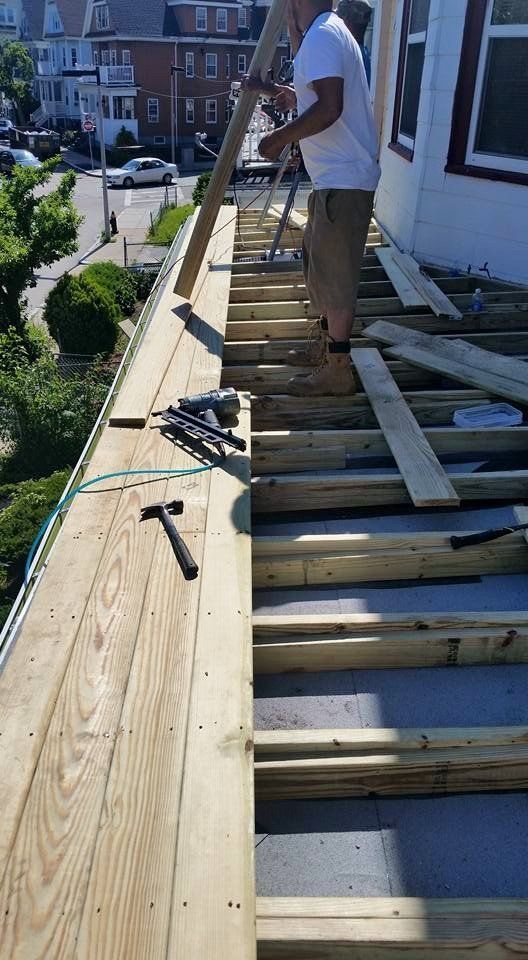 A man is standing on top of a wooden deck.