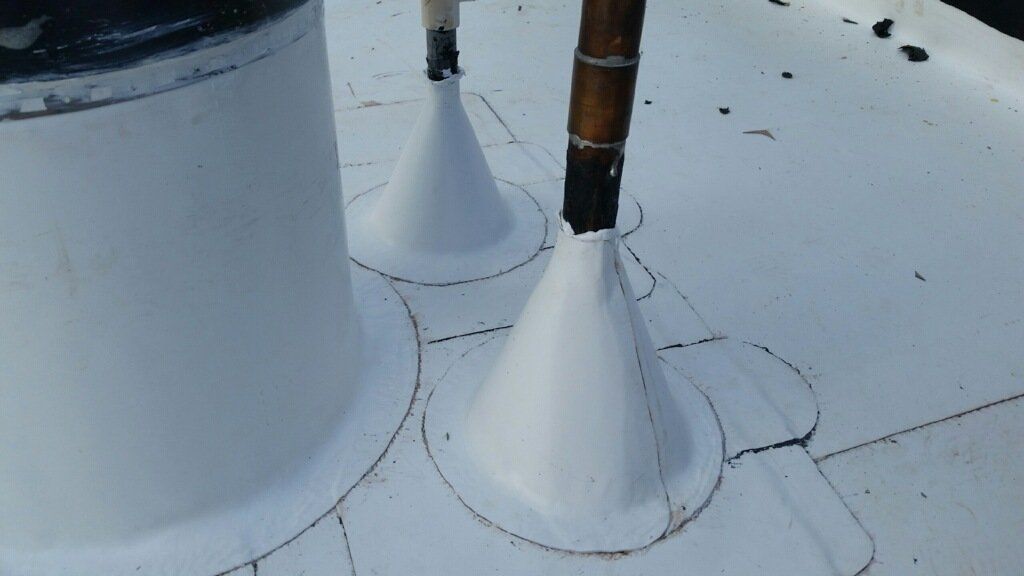 A close up of a white roof with two cones on it.