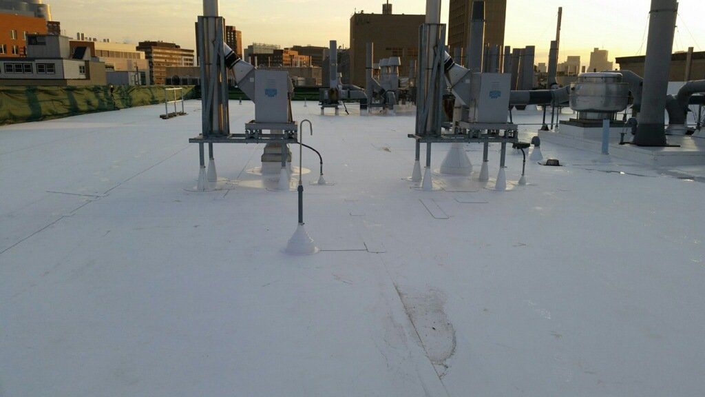 A white roof with a lot of pipes on it