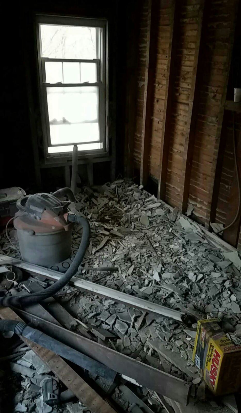 A room with a vacuum cleaner on the floor and a window.