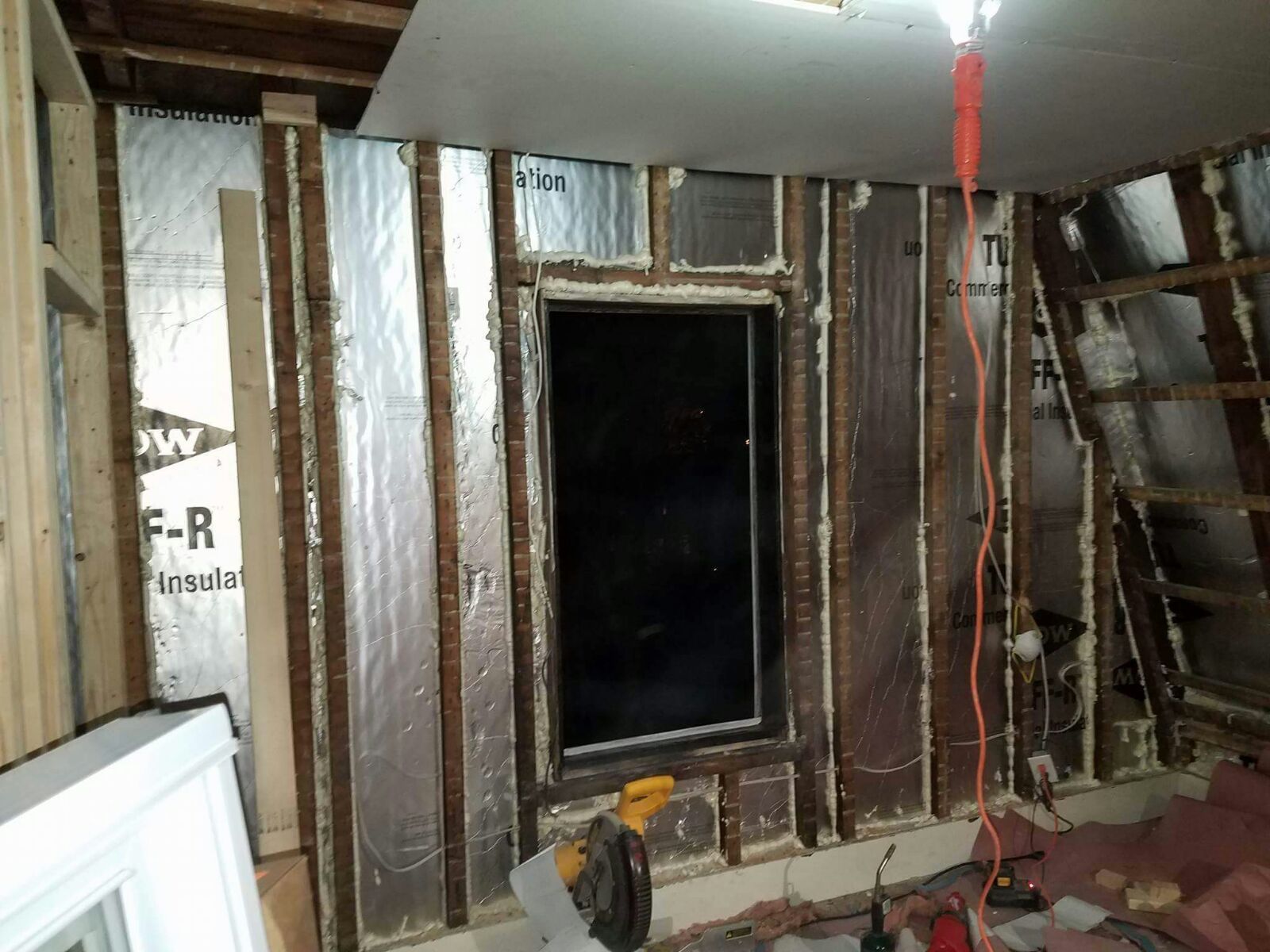 A room under construction with a window and a ladder.