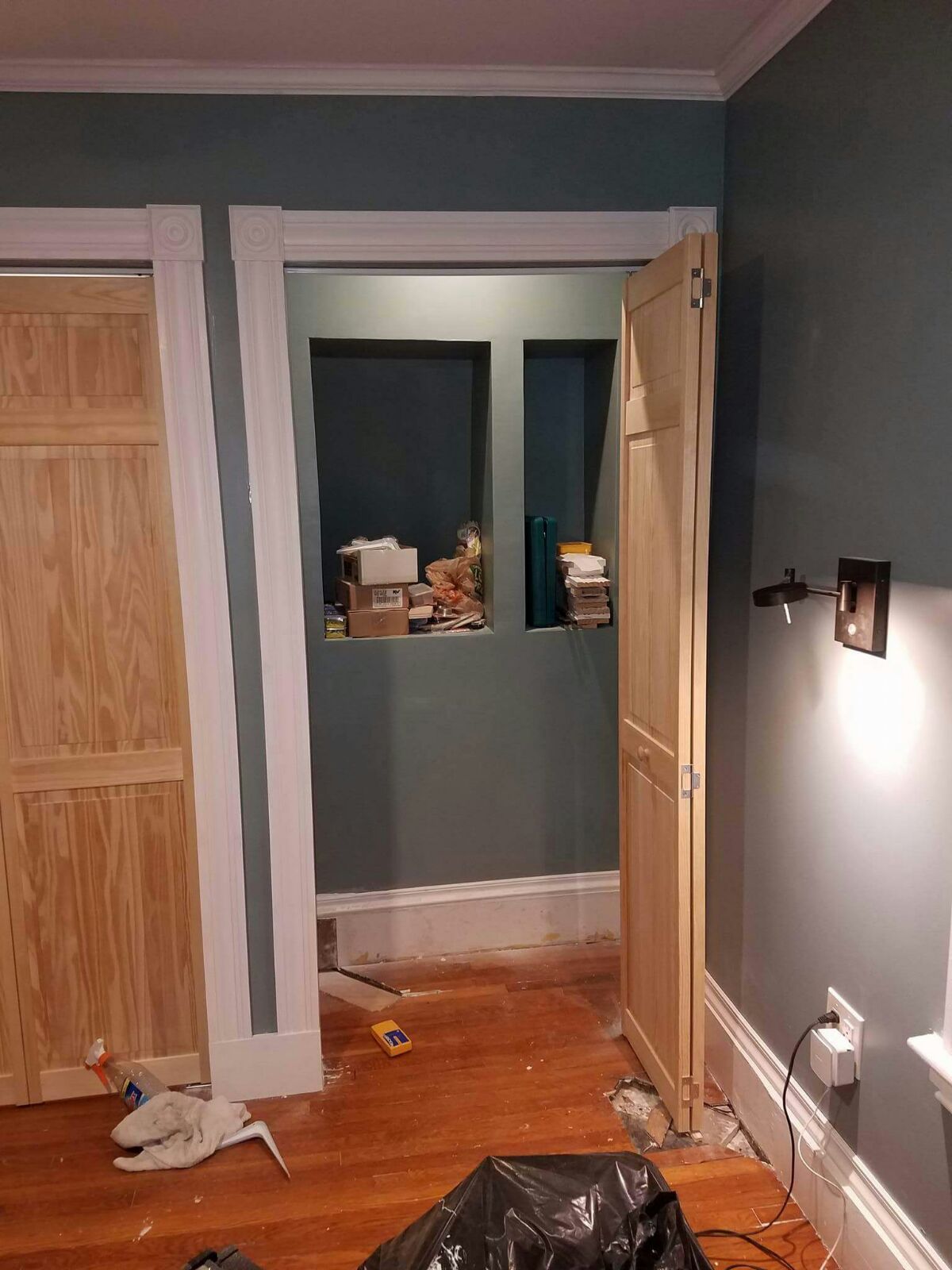 A room with wooden doors and a black bag on the floor.