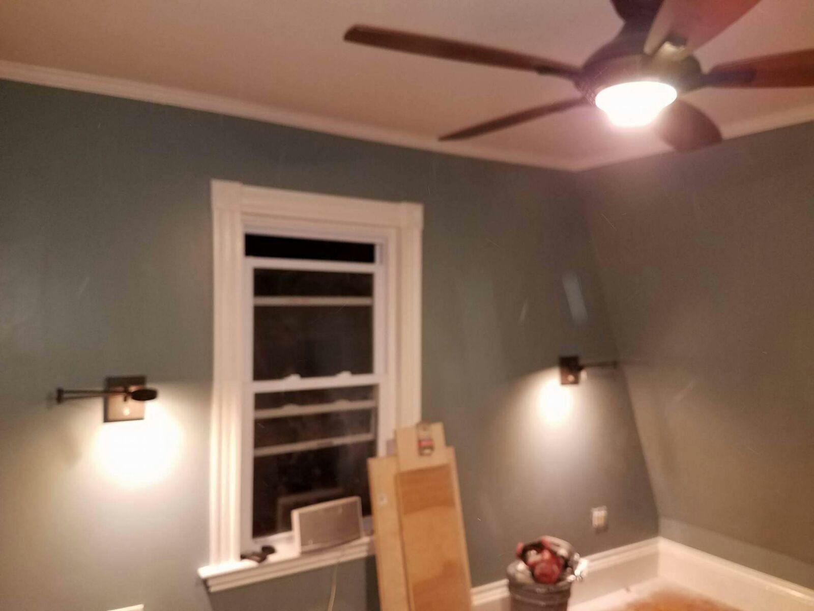 A room with a ceiling fan and a window