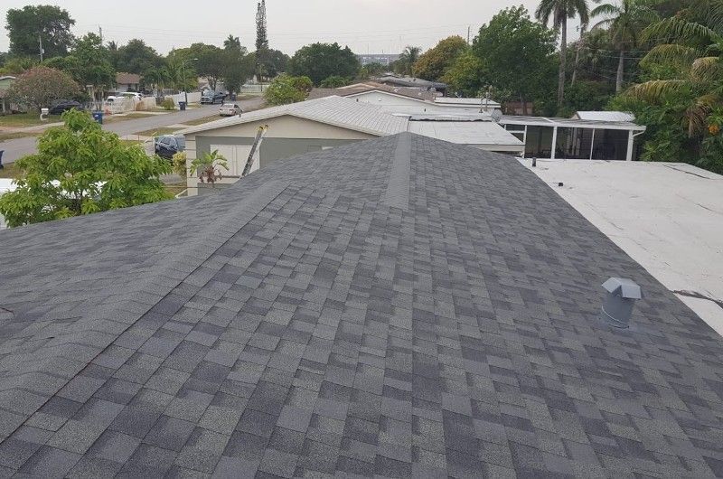 The roof of a house with a black shingle roof and a white roof.