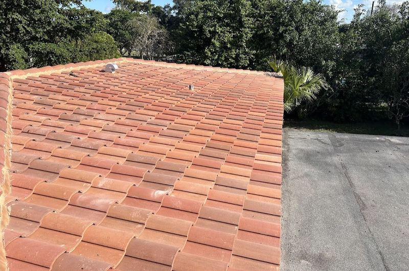 A roof with a lot of tiles on it and trees in the background.
