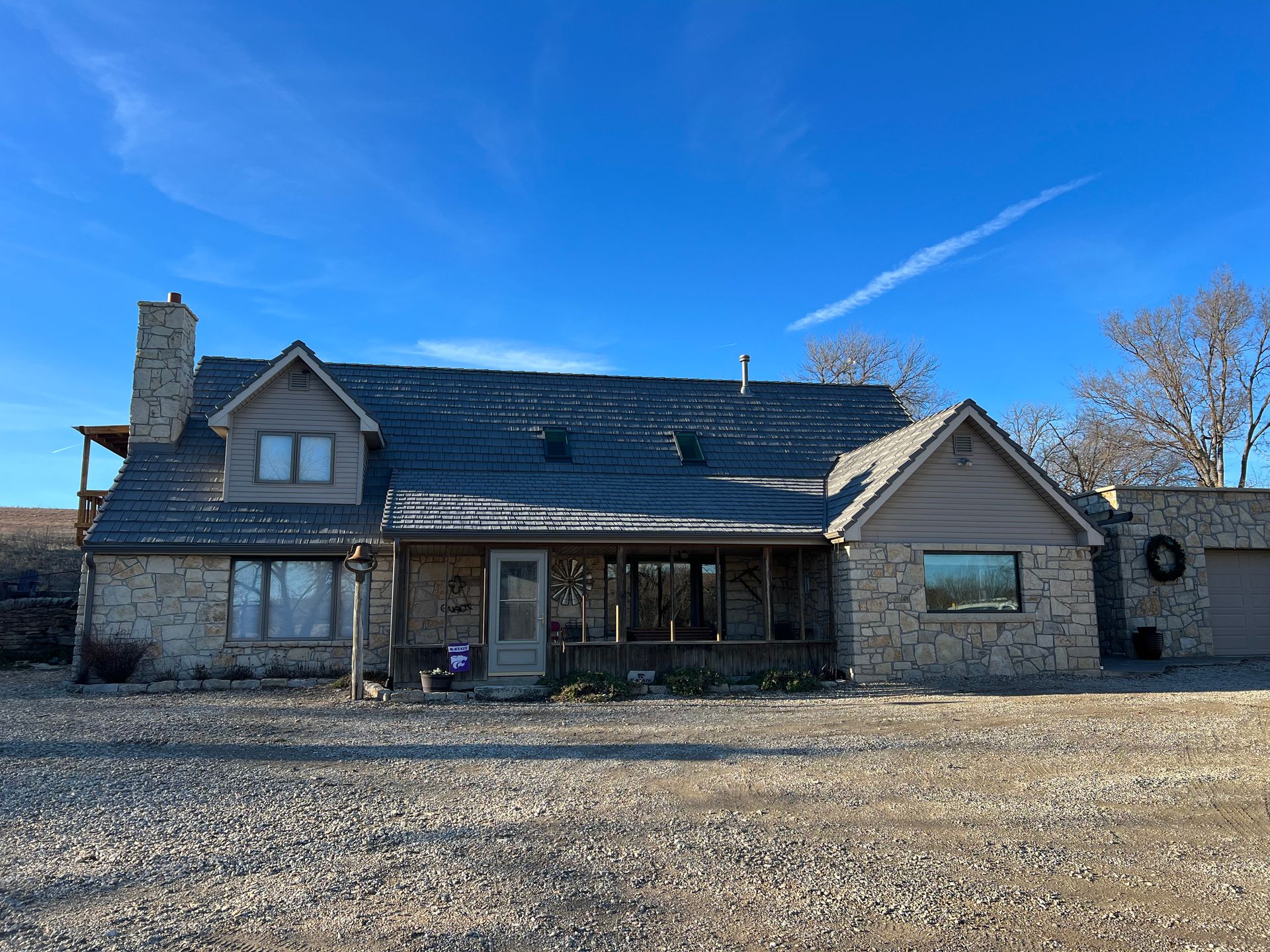 A large stone house with a blue sky in the background.