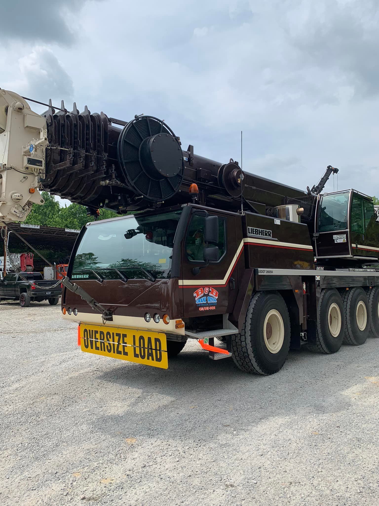 A large crane is parked in a gravel lot.