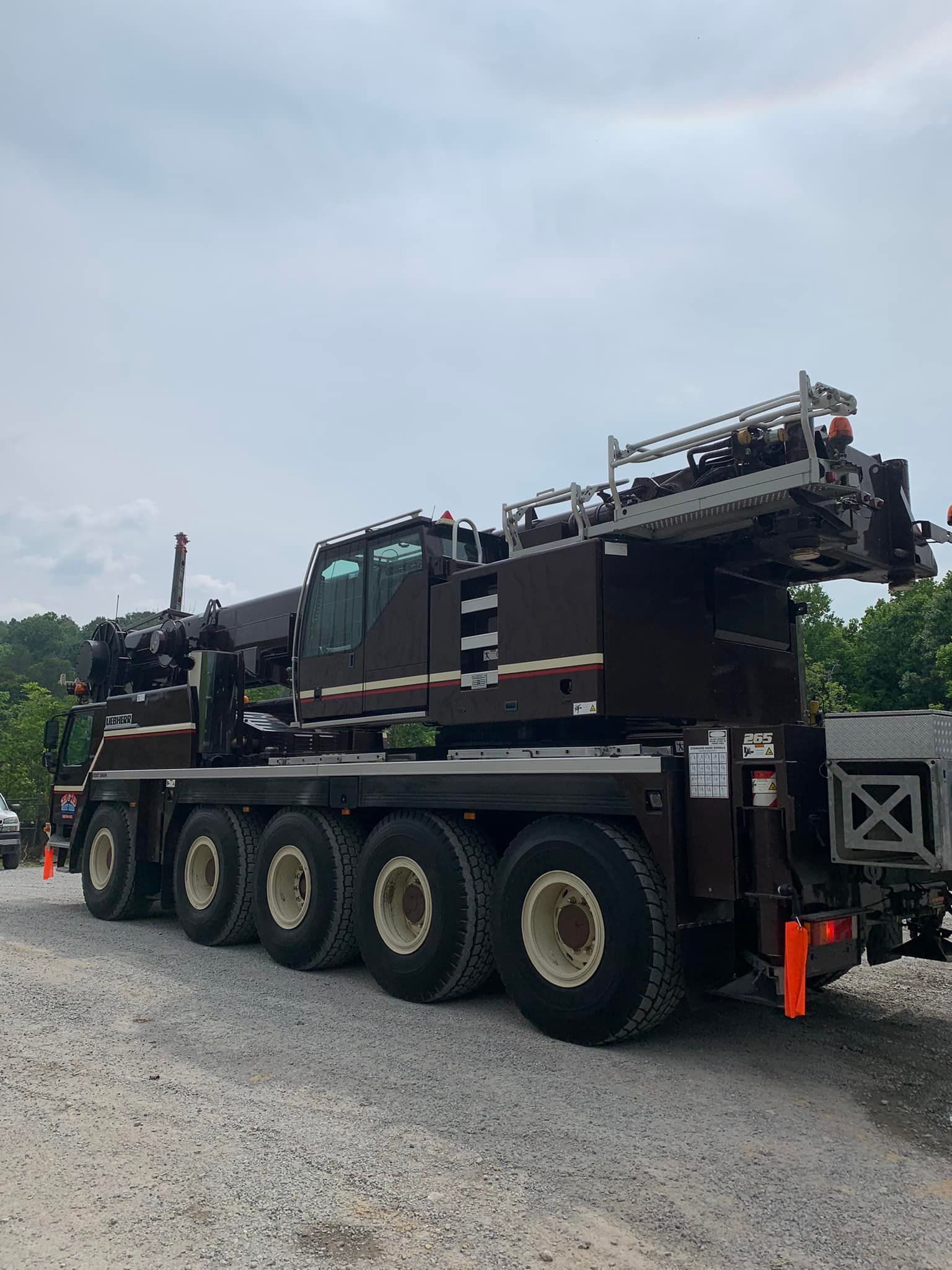 A large crane is parked in a gravel lot.