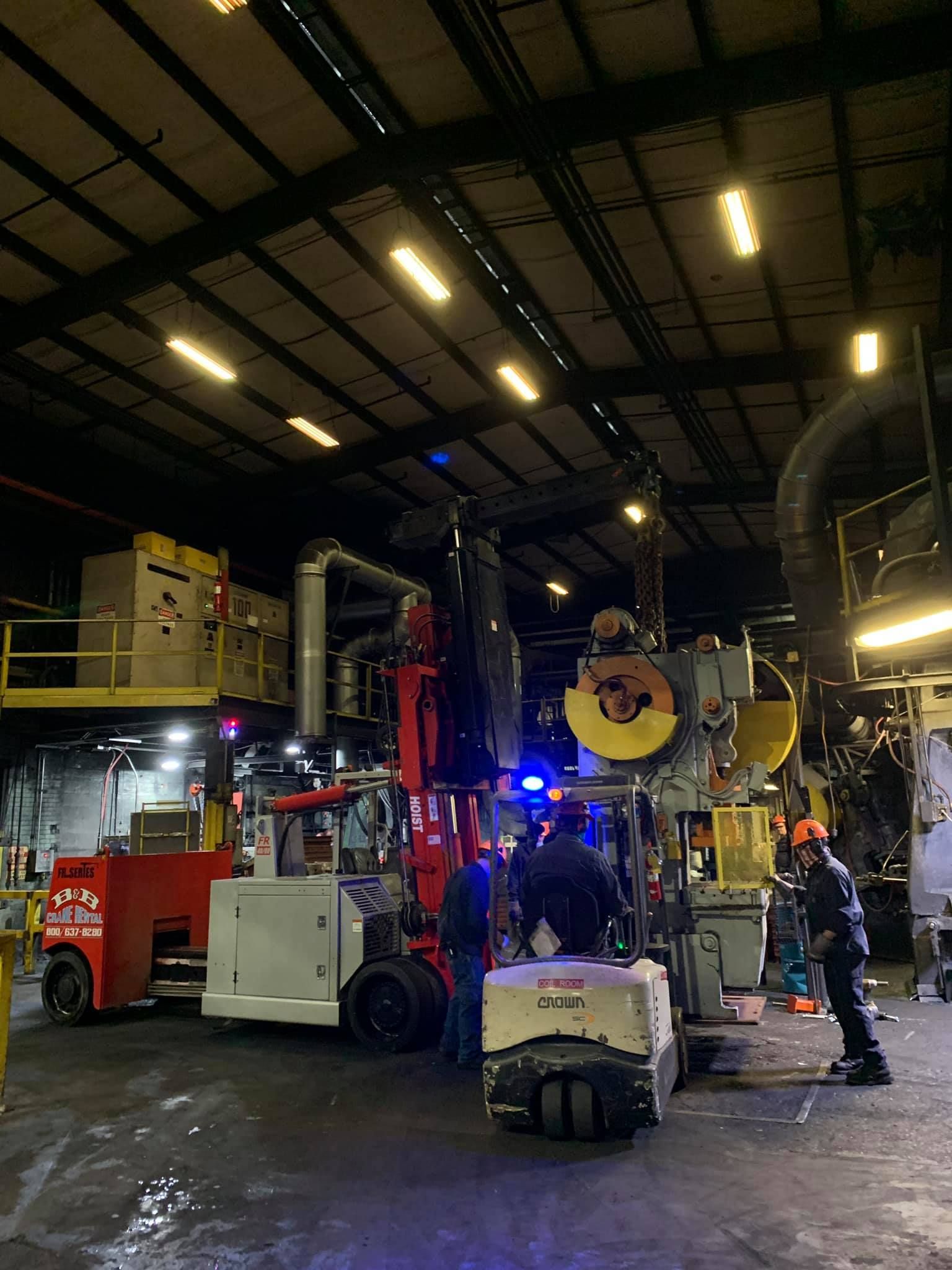 A group of people are working on a machine in a factory.