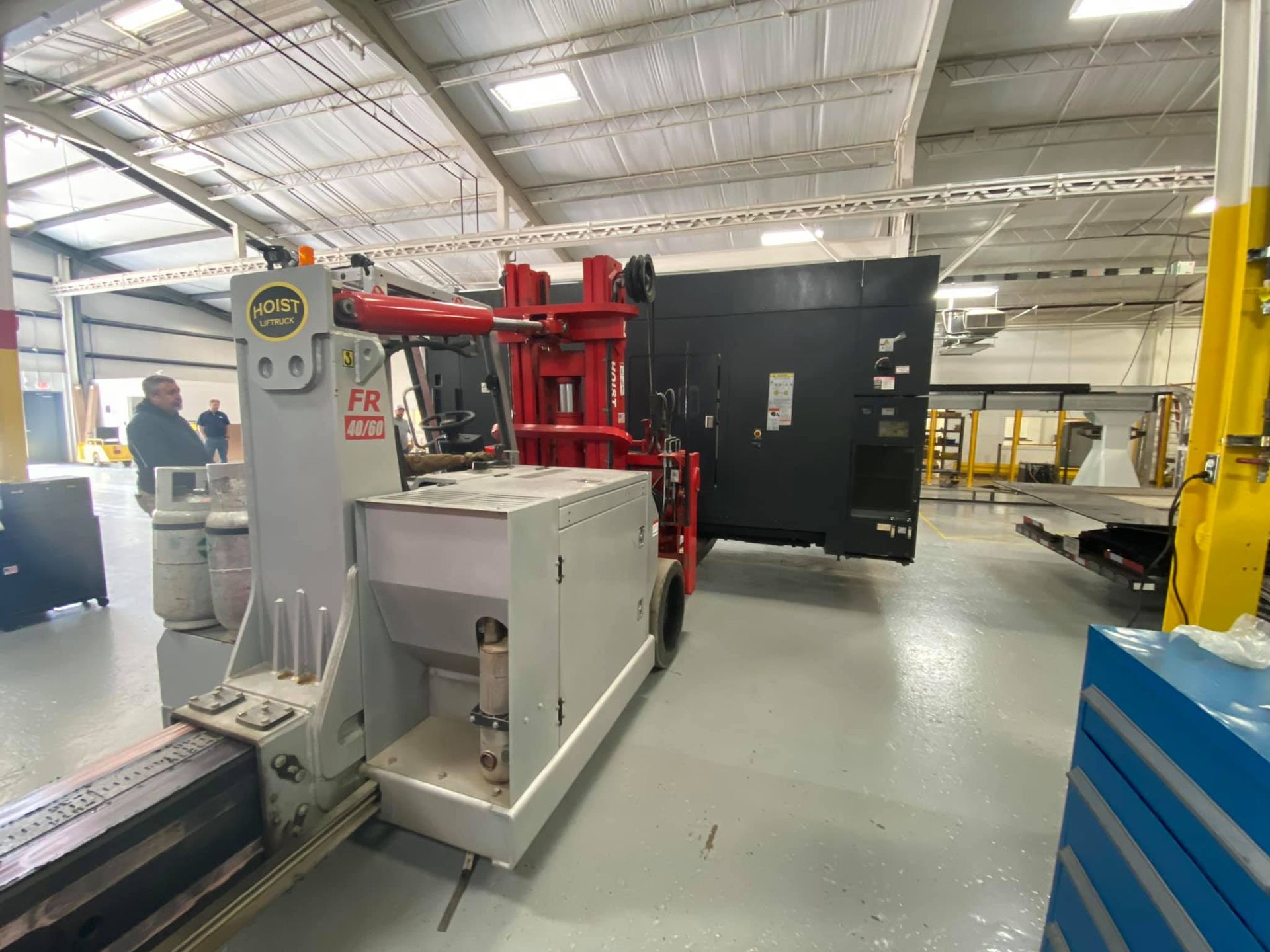 A large machine is being moved in a warehouse.