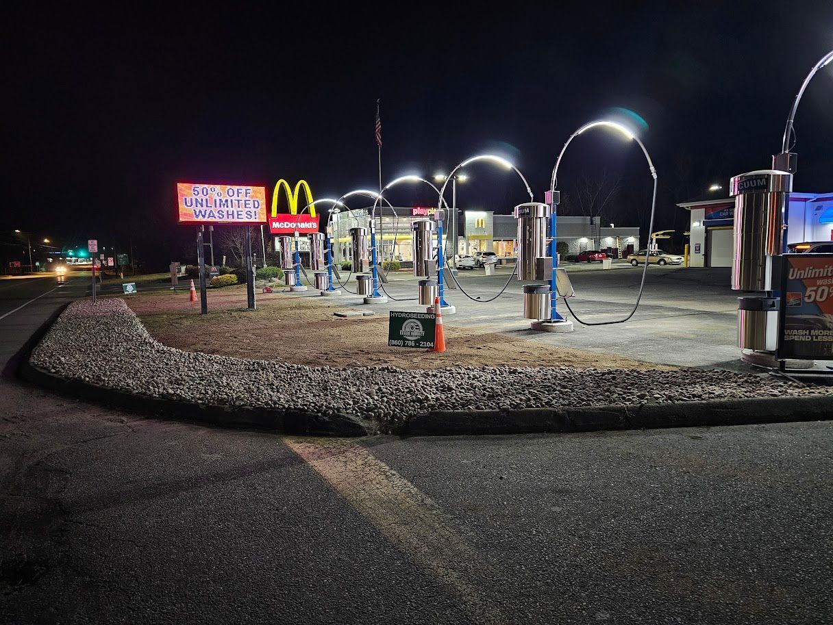 A row of illuminated car wash vacuums at night
