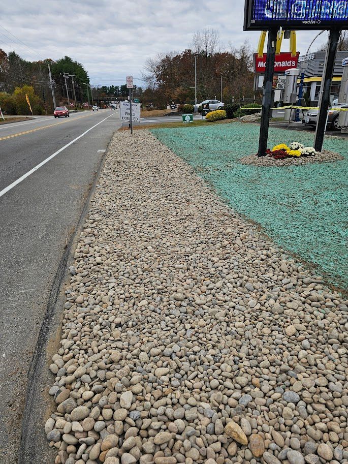 A road runs past a gravel landscape, featuring a large sign for a McDonald's restaurant