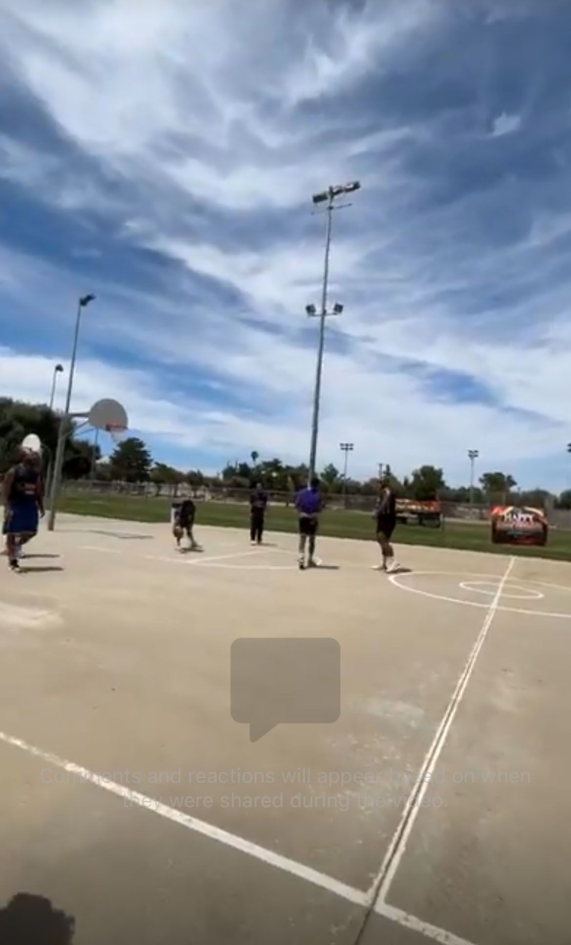 A group of people is playing basketball on a court.