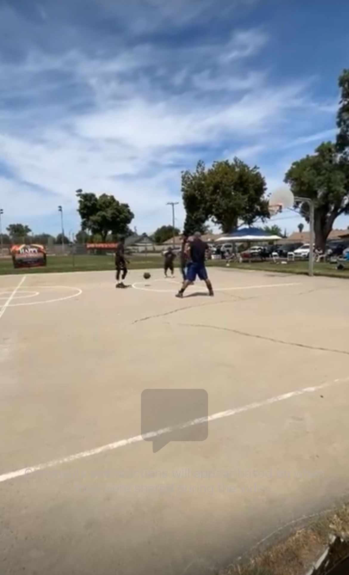 A group of people is playing basketball in a park.