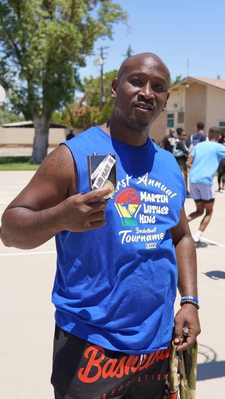 man with 2nd place award on a basketball court