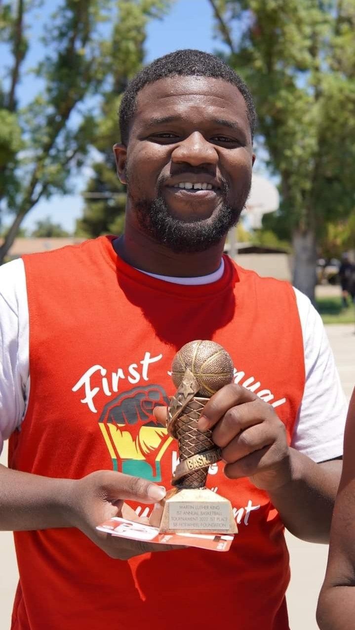 man with basketball trophy on hand